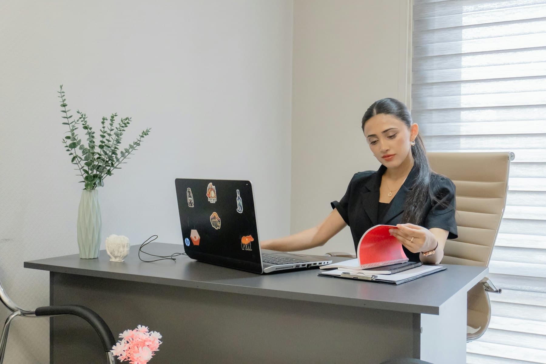 Personne travaillant sur un ordinateur portable en consultant des documents